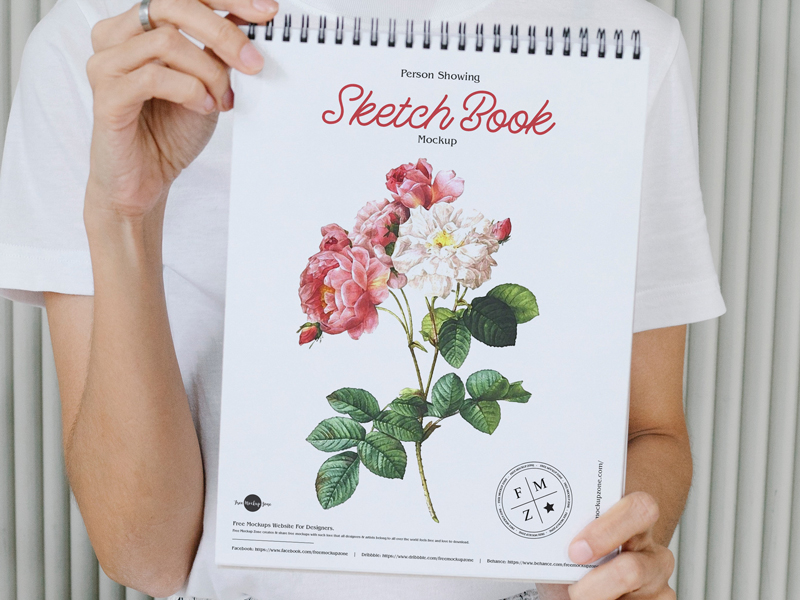 Free-Person-Showing-Sketch-Book-Mockup-600