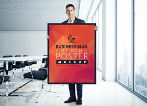 Free-Man-Holding-Poster-MockUp-in-Office-2017